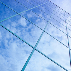 Wall Mural - reflections of clouds and blue sky in facade