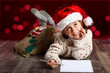 © javiindy - Adorable little girl wearing santa hat writing Santa letter