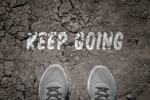Sneakers On Dry Land With The Text: Keep Going