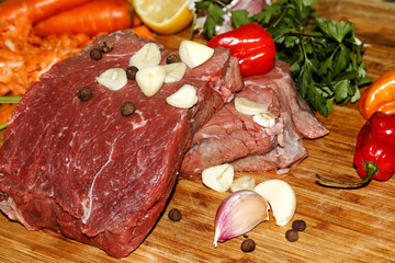 Raw steak with vegetables. Tenderloin steak with seasoning, fresh vegetables and spices. Beef steak composition. Food background.