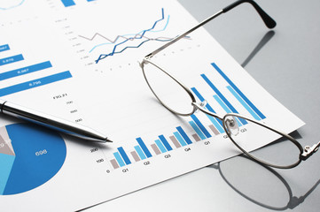 Poster - Blue charts, glasses and pen. Financial report on gray reflection background.
