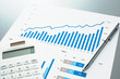 © tadamichi - Reviewing financial report. Graphs and charts.　Business document, calculator and pen.