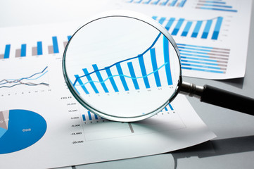 Poster - Reviewing financial reports. Graphs and charts.　Financial reports, documents and magnifying glass. 
