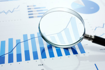 Poster - Looking at growth chart with magnifying glass.　Graphs, charts and magnifying glass on reflection background.
