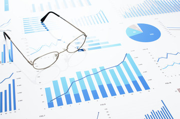 Poster - Many charts and glasses. Reviewing data.　Financial reports and glasses. Reflection background.
