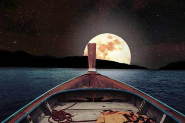 Wall Mural - traveling on wooden boat at night with full moon and stars on sky. romantic and scenic panorama with