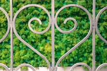 Closeup On Love Heart Shape Railing. Railing Of The Shape Of A Heart With Elegant Curves. Dark Grey Color On Green Background.