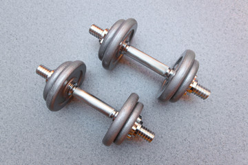 two sports dumbbells on a grey background