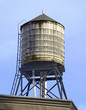 Vintage wooded water tanks on roof of apartment building in New York City hold water that is sourced from the Catskill Mountains
