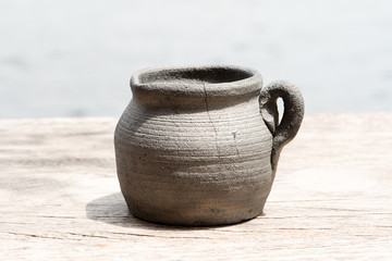 Clay pot on wooden table in natural light