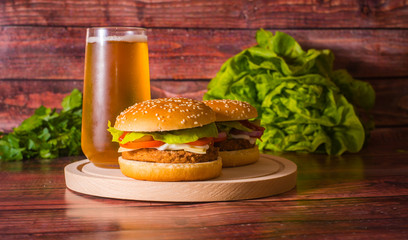 Hamburger and beer on wooden board