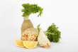 Fresh celery root vegetable with slice of lemon, white background, vertical