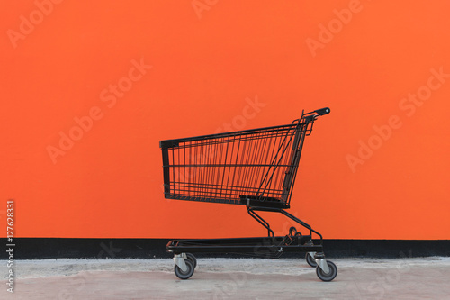 Fotografía Minimalism style, Shopping cart and orange wall.