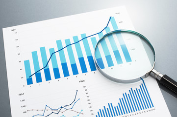 Poster - Reviewing business report. Looking at growth chart with magnifying glass.
Document, charts and magnifying glass on gray reflection background.
