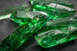Closeup of a bunch of many green rough uncut emerald crystals