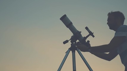 Wall Mural - man looking through a telescope.