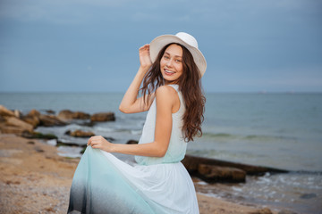 Wall Mural - Happy attractive young woman walking on the beach