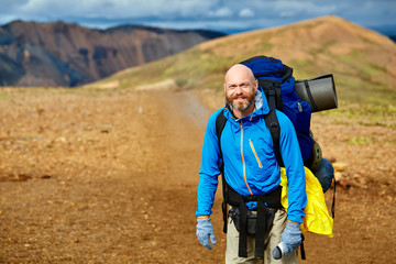 Wall Mural - man hiker on the trail in the rhyolite Islandic mountains. Trek in National Park Landmannalaugar, Iceland