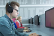 © Myvisuals - Young software engineer working in office with headphones on his