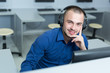 © Myvisuals - Young software engineer working in office with headphones on his