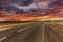 Picturesque Fiery Sunset Over The Cracked Desert Road