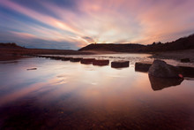 Sunset At The Stepping Stones That Allow Access To The Divided Beaches At Three Cliffs Bay On The Gower Peninsula In Swansea, South Wales
