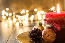 Red Christmas Candle And Christmas Ornaments On Wood
