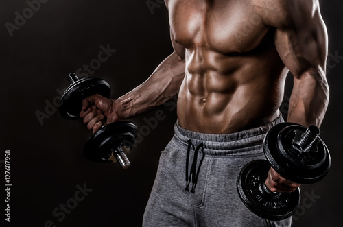 Powerful Body of Athlete Bodybuilder Posing with Dumbbells Plakat
