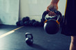 © baranq - Close-up of athletic man holding kettlebell weight at gym