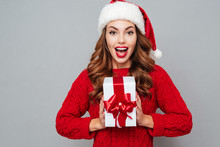 Happy Excited Woman In Santa Claus Hat With Gift Box
