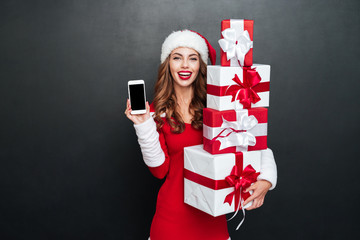 Woman in red christmas outfit showing blank screen mobile phone