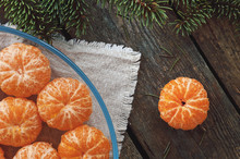 Peeled Tangerines On A Plate On A Wooden Background And Fir Branch