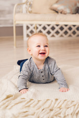 Adorable baby boy in sunny bedroom. Newborn child relaxing. Family morning at home. New born kid during tummy time.