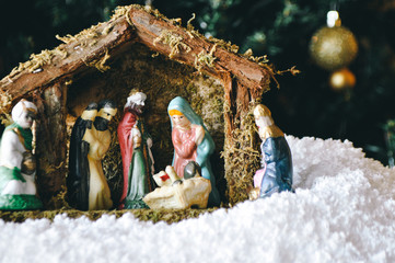 Christmas Manger scene with figurines including Jesus, Mary, Joseph, sheep and magi.

