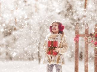 Wall Mural - girl with Christmas gift on a winter walk