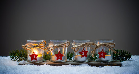 four advent candles in the snow