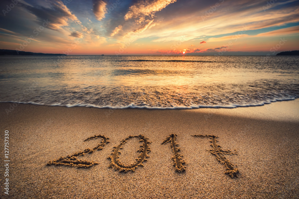 Happy New Year 2017 concept on the sea beach at sunrise - obrazy, fototapety, plakaty 