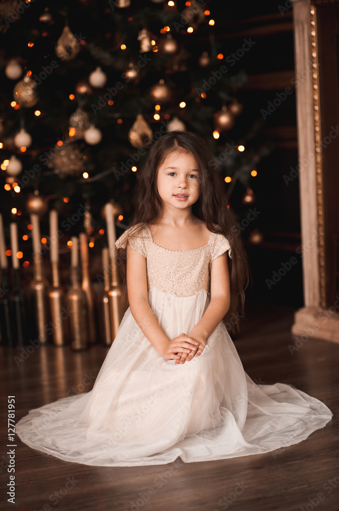5 year old christmas dress Cute baby girl 4-5 wearing stylish sitting under tree with lights in room. Looking at camera. Holiday season. Stock-foto Cozy Up Your Little