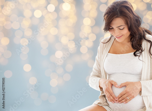 Fotomural happy pregnant woman making heart gesture in bed