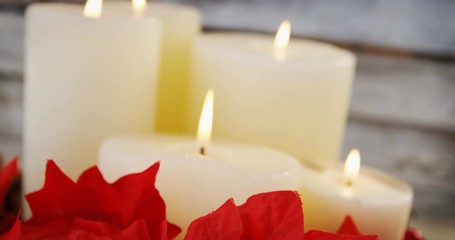 Poster - Candles decorated with flowers on wooden plank