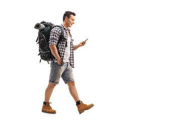 Canvas Print - Hiker walking and looking at a mobile phone