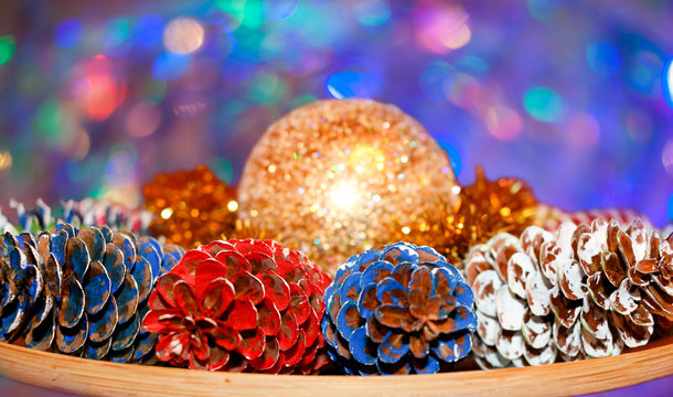 Golden ball in middle of composition of colored pine cones on co