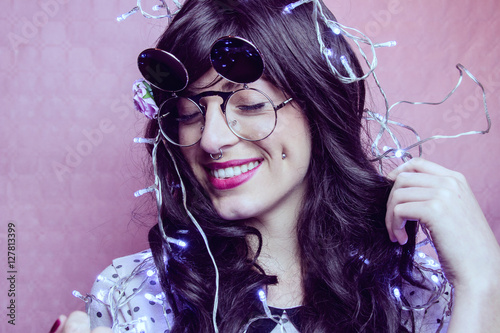 Fotografie, Obraz Chica hipster joven y guapa pasándolo bien en una fiesta decorada con luces de n