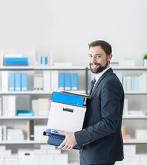 Wall Mural - Businessman carrying a box and office folders