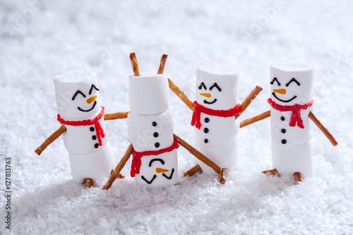 Fotografering Happy funny marshmallow snowmans on snow