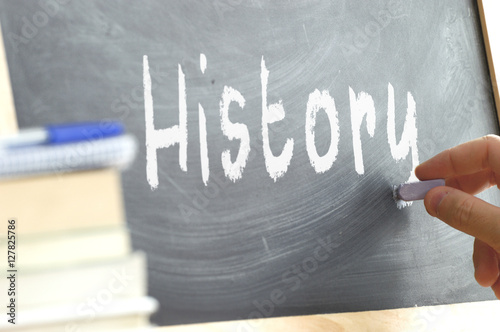 Foto A person writing in a blackboard during History class in a school