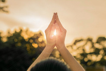 Silhouette people pray from Buddha statue to hope for help on sun set and bokeh background. Inspiration from help to hope, Put the palms of the hands together in salute.