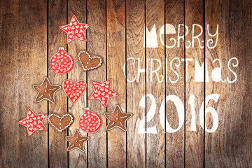 Wall Mural - Christmas greeting card 2016, rustic ornaments on wood planks background creating the shape of a Christmas tree