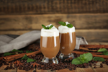 Poster - Delicious chocolate milk dessert with coffee beans and mint on wooden background