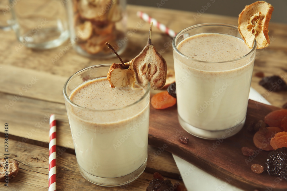 Milk shakes with dried fruits on wooden table
